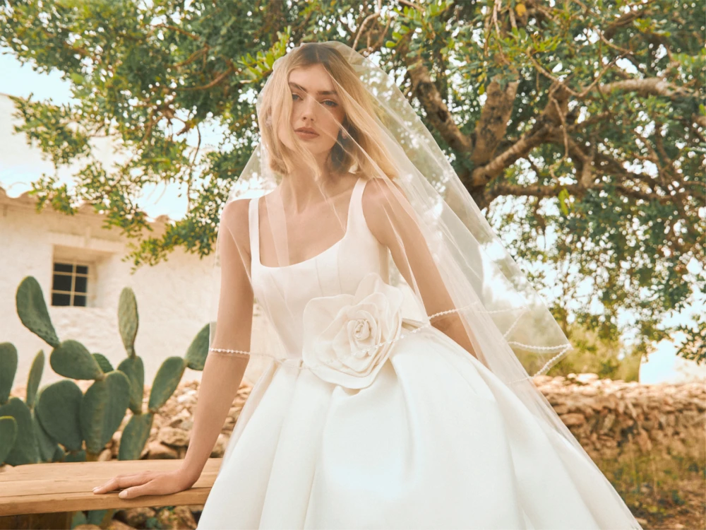 Model in wedding dress with big flower and veil