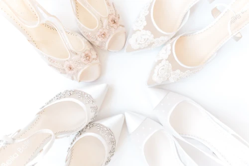 4 pairs of wedding shoes arranged in a circle shown against a white background