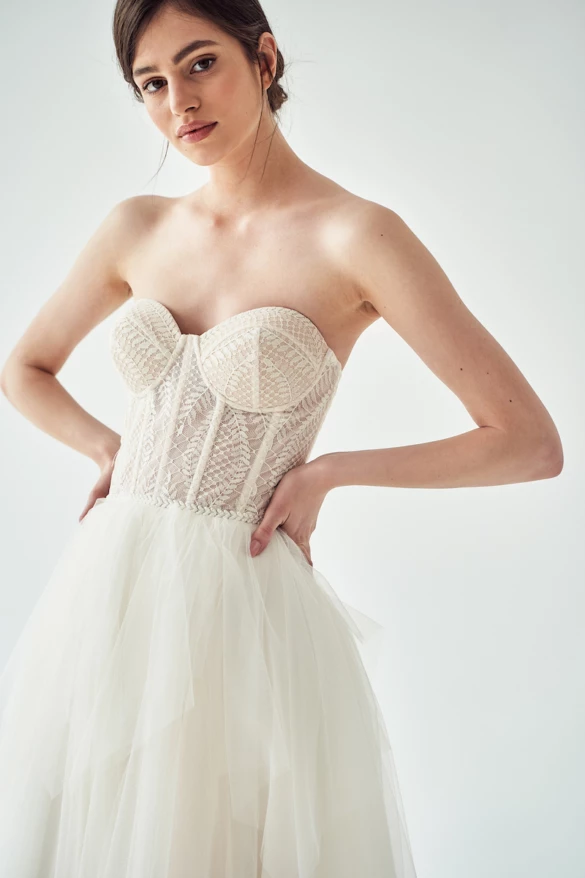 Model posing in a lace and tulle a-line wedding dress.