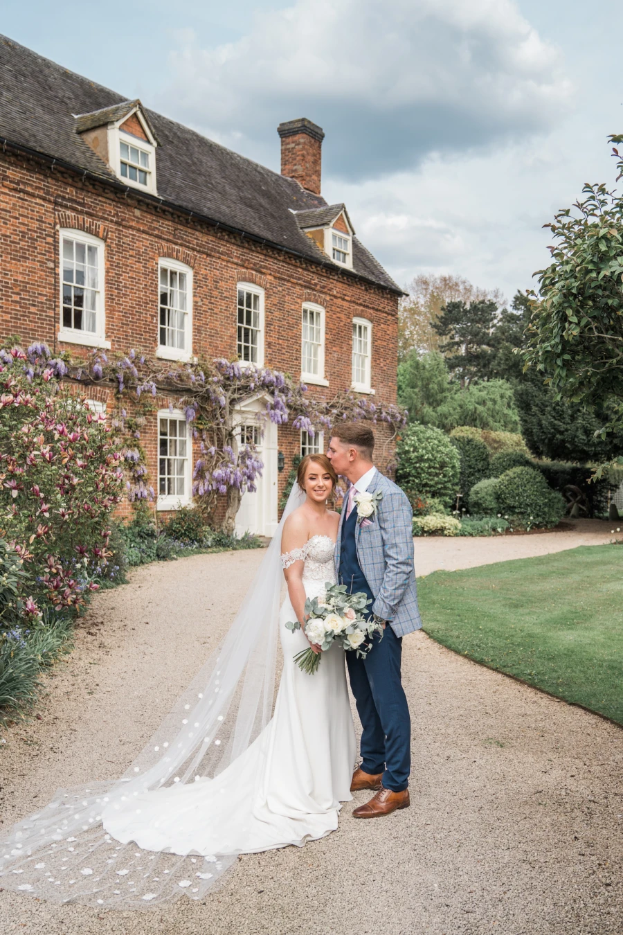 Bride and groom on driveway outside a country house